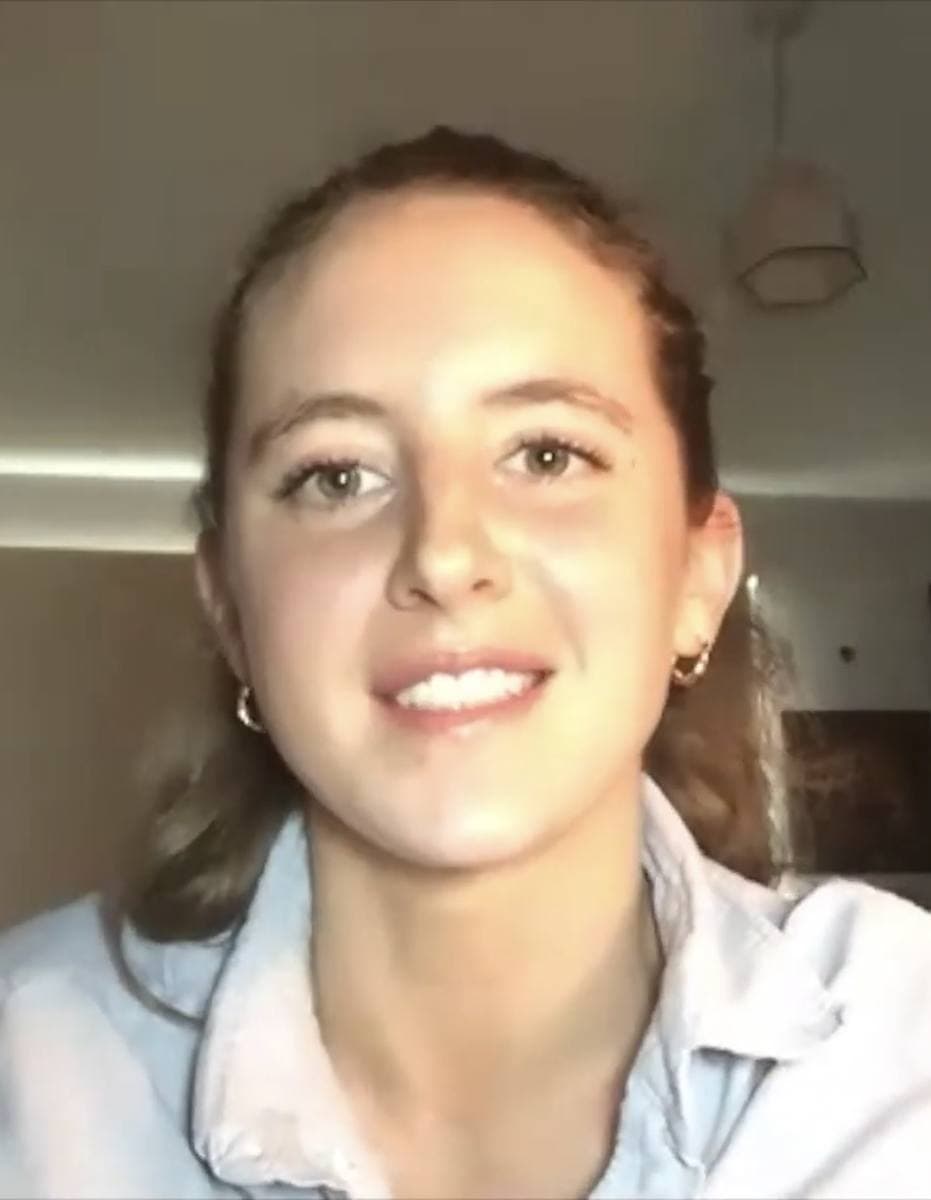 Louisa Harland smiling into a webcam, in a pale shirt