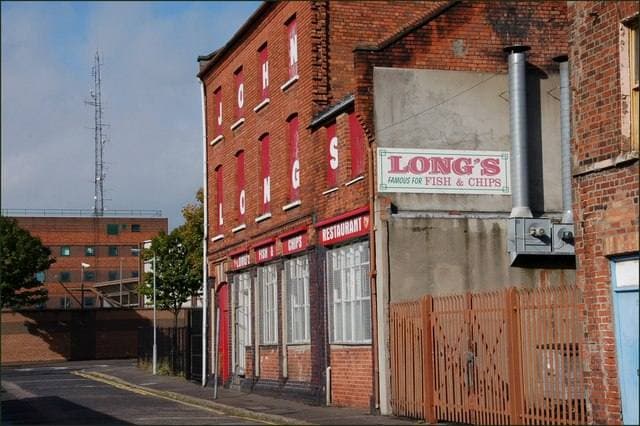 A red-brick building with a sign reading LONG’S fish and chips on a quiet side street