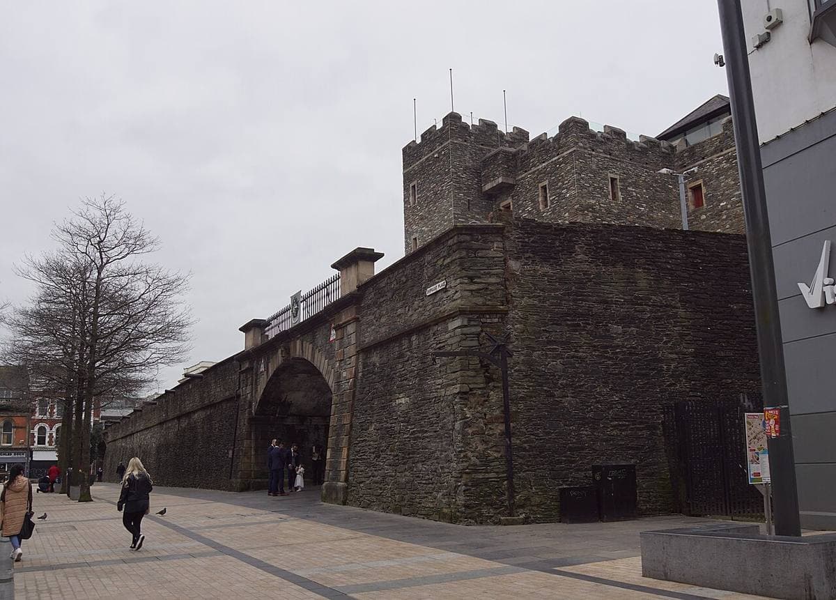 A stone tower-house and an arched gate in the city wall