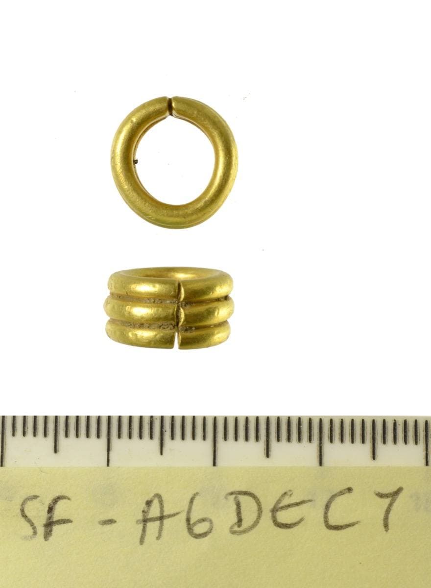 A tiny ring made of three bands of gold side by side