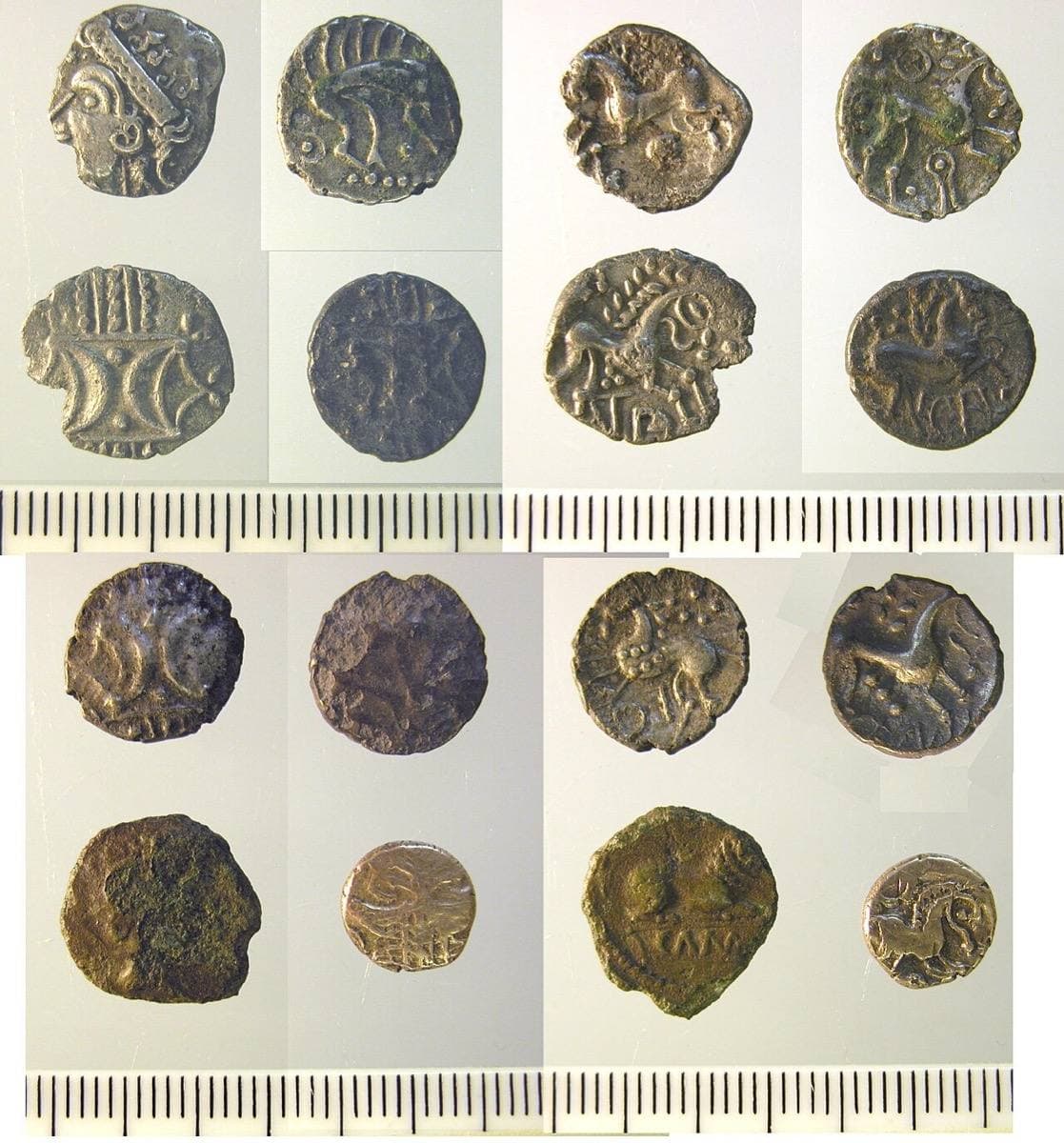 Eight small worn coins of gold, silver and bronze laid out in rows