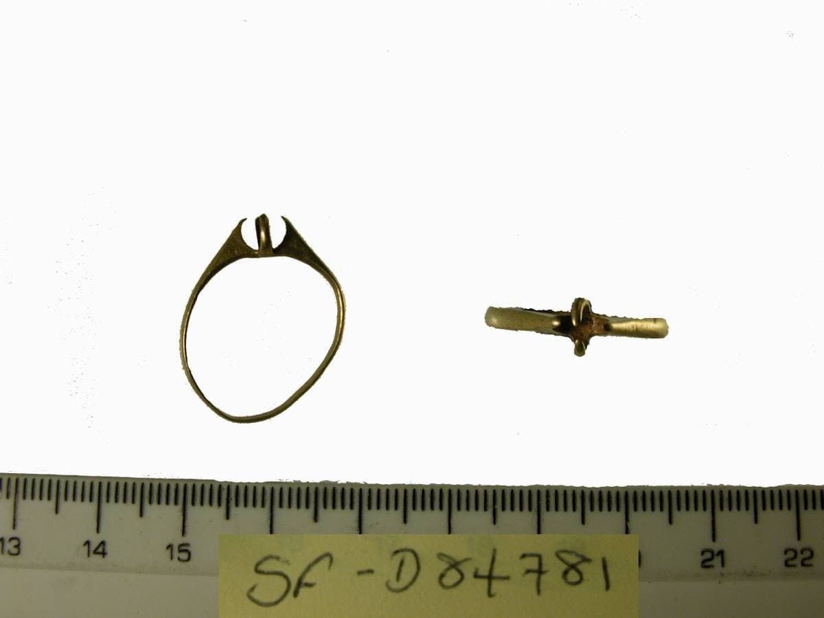A small distorted gold ring with four claws that once held a stone