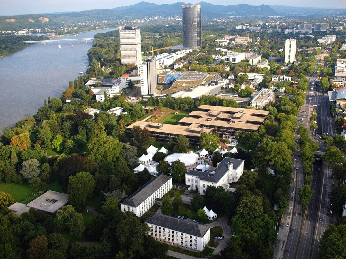 Aerial view of government buildings among trees beside the river Rhine