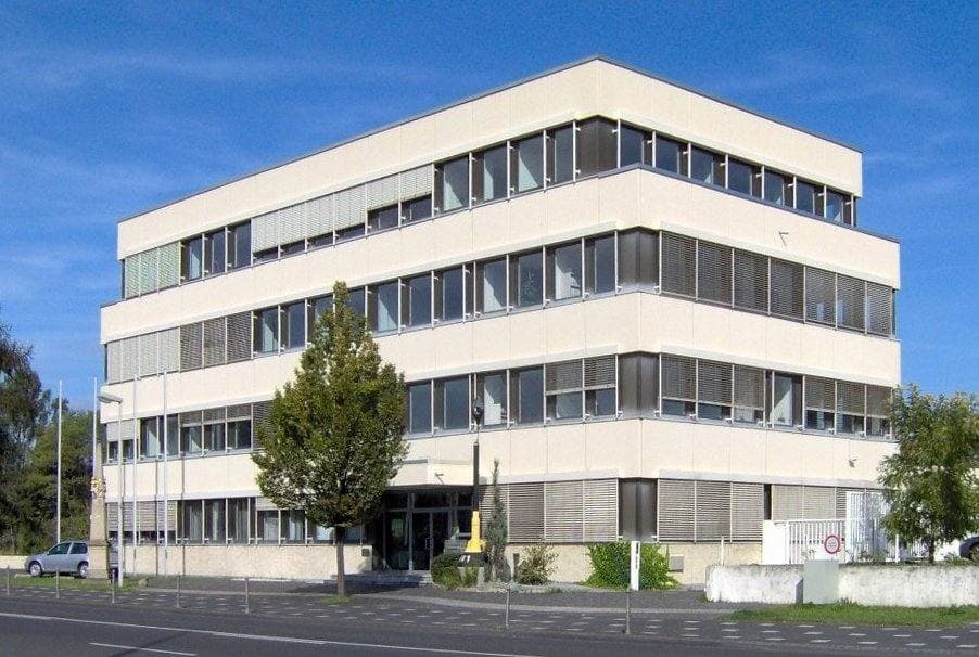 A white four-storey office block with ribbon windows