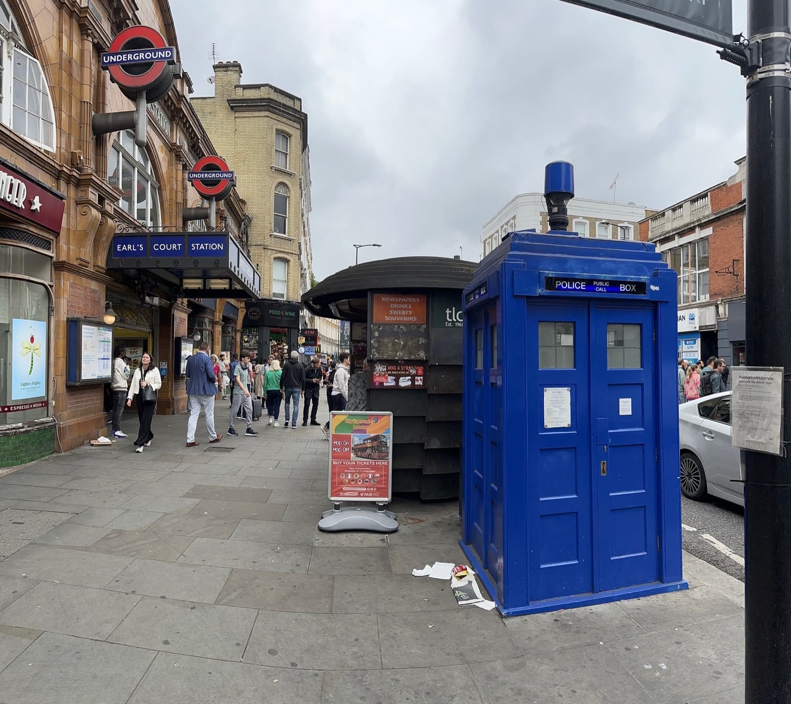A blue police box on the pavement outside Earl’s Court station