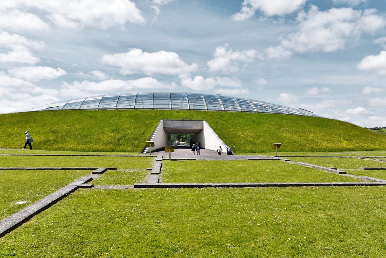 A low glass dome rising out of a grassy hill