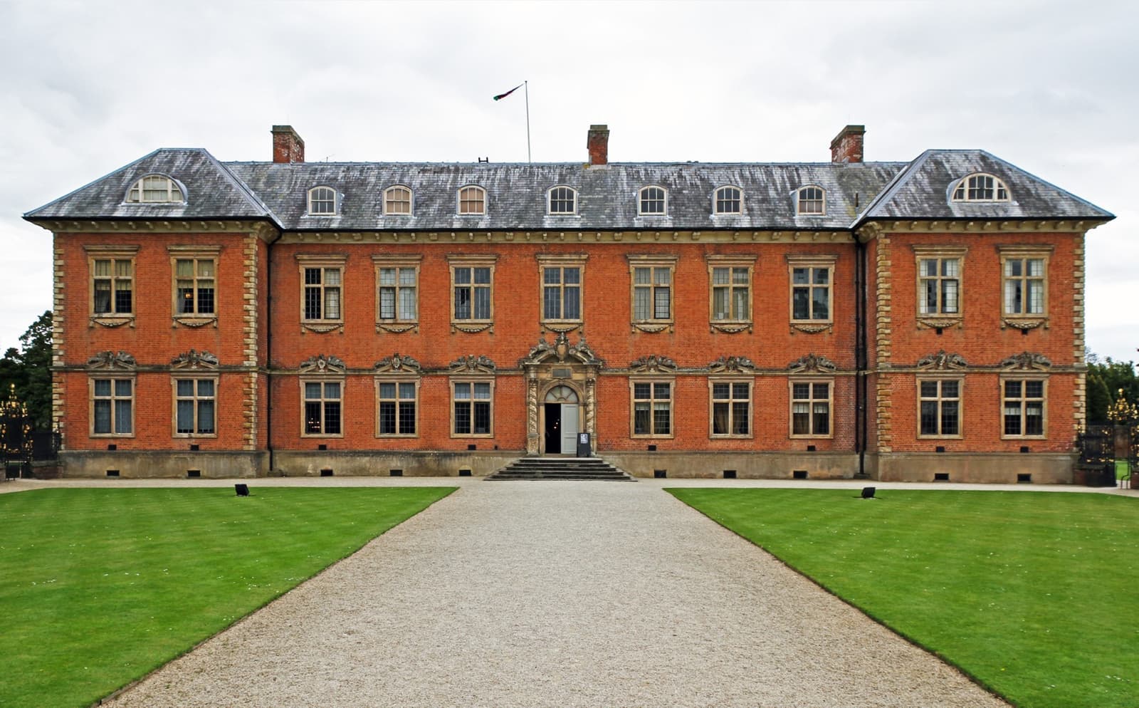 The red-brick front of Tredegar House at the end of a gravel drive