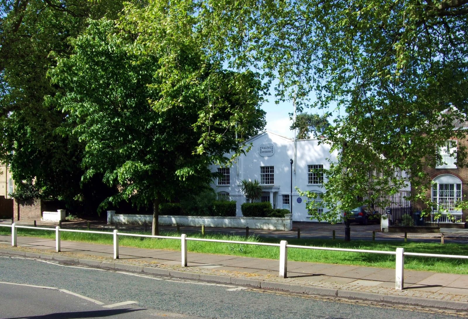 The white front of Ealing Studios behind railings