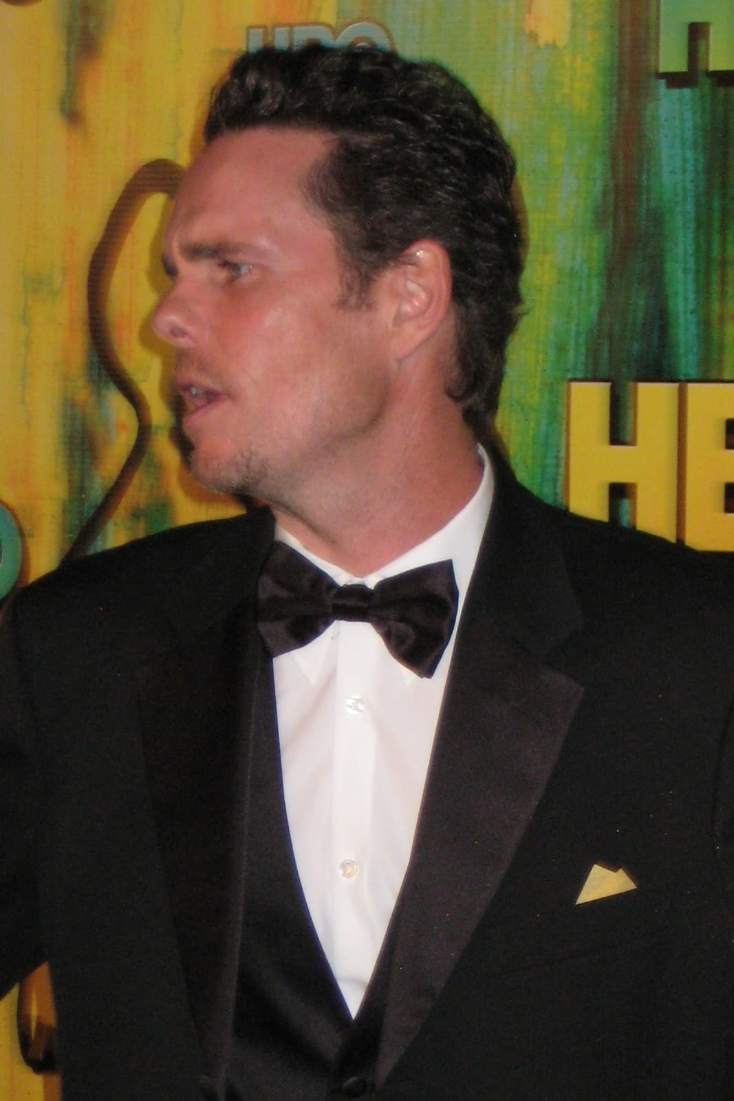 Kevin Dillon in a black tuxedo and bow tie