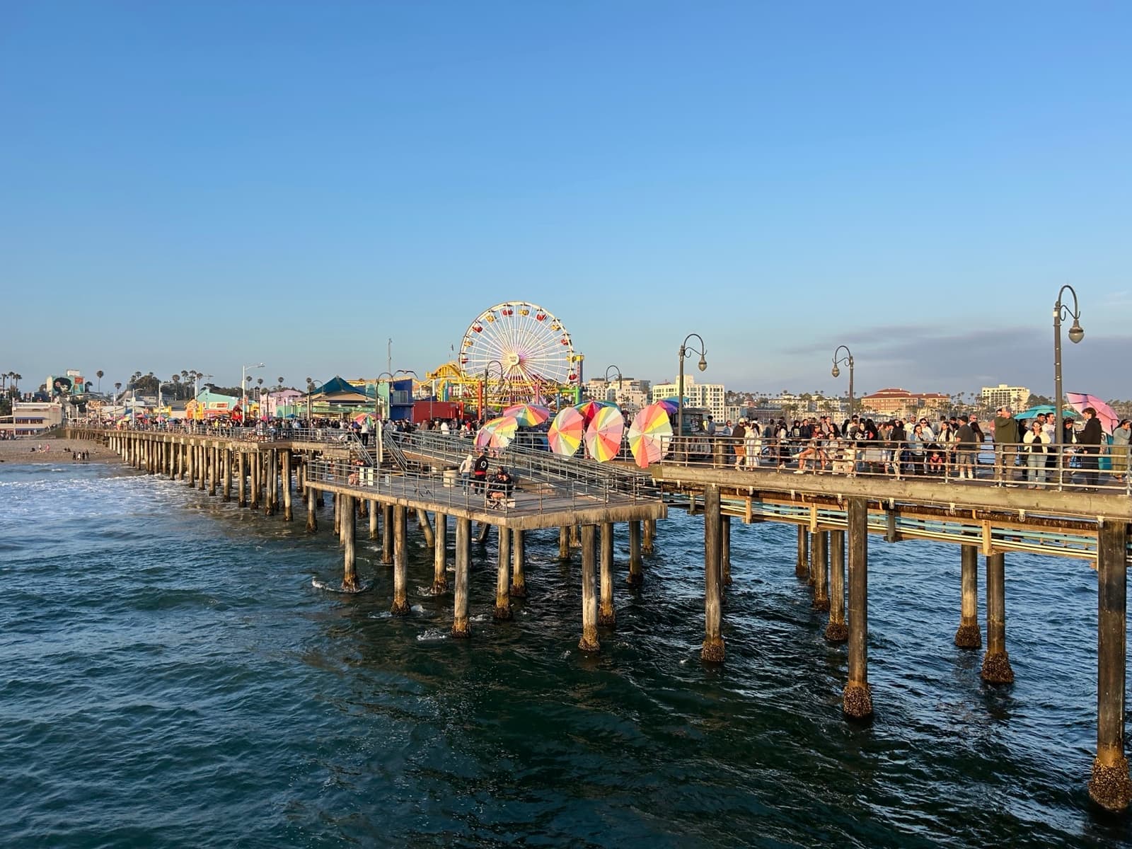 The pier stretching out over the sea with a Ferris wheel at its end