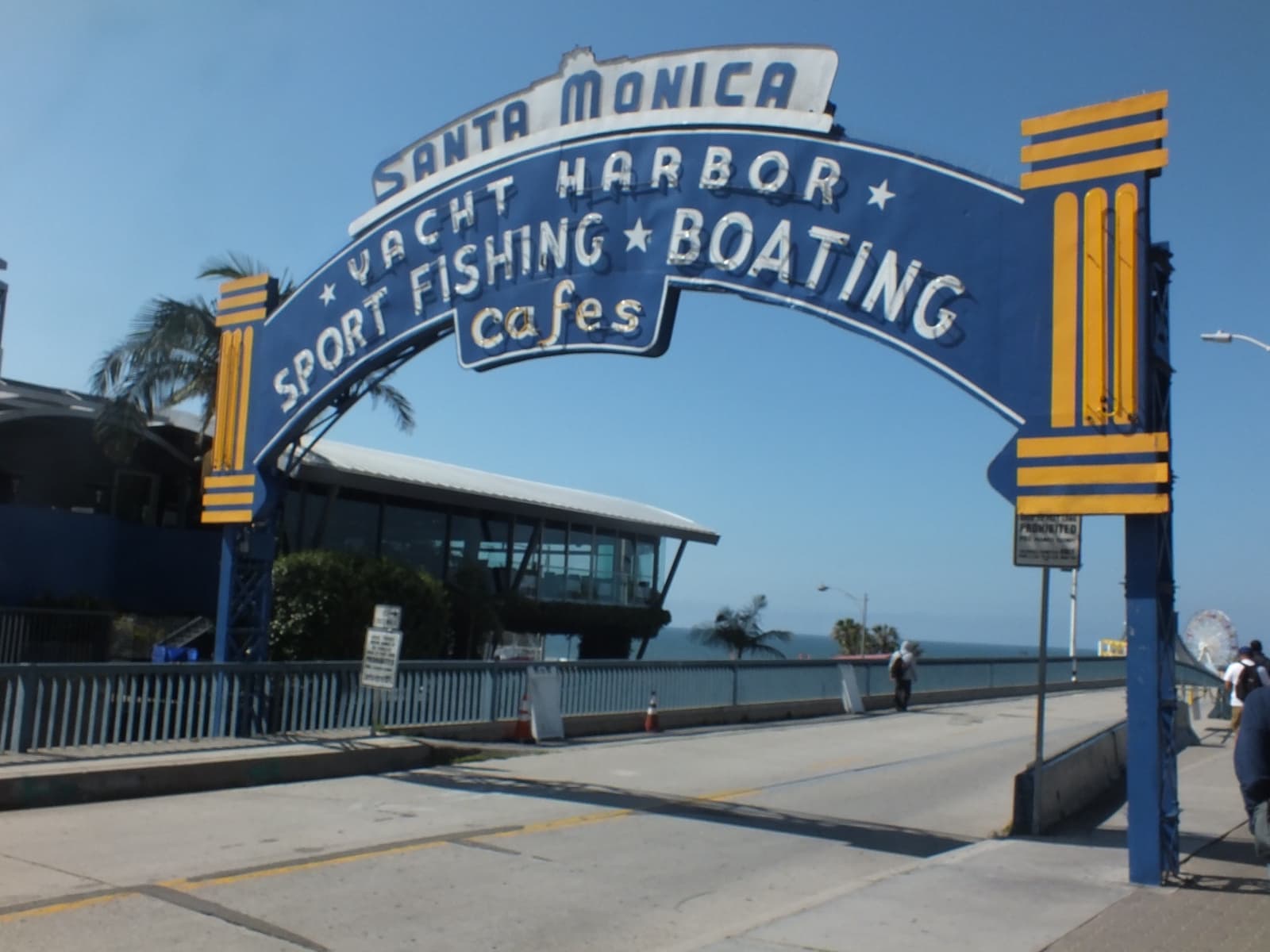 A blue arched sign over the road onto Santa Monica Pier