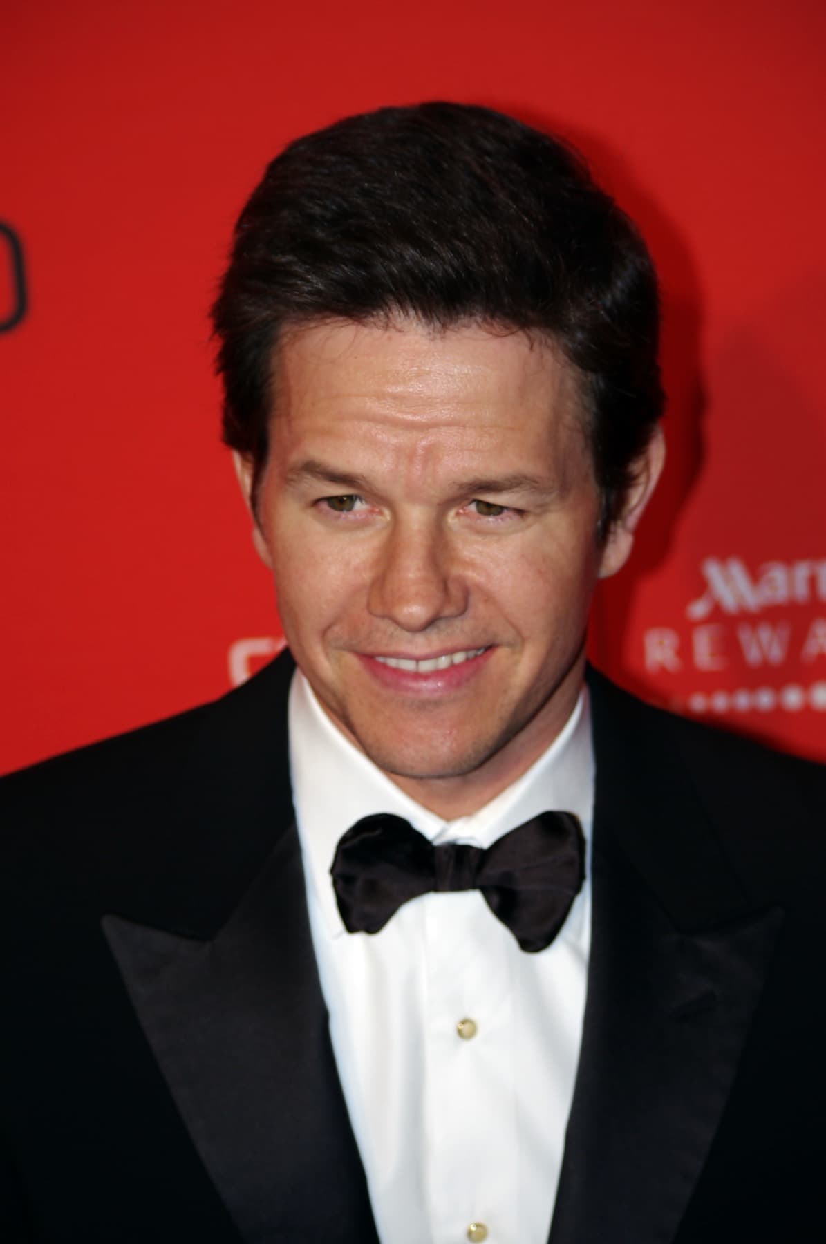 Mark Wahlberg in a tuxedo and bow tie, smiling