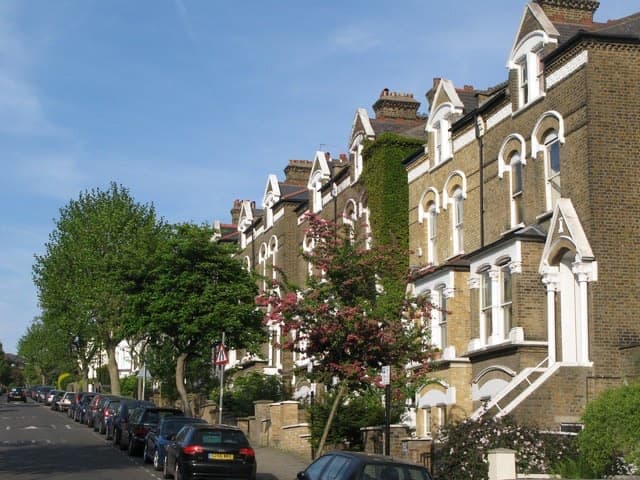 A quiet tree-lined road of Victorian terraces