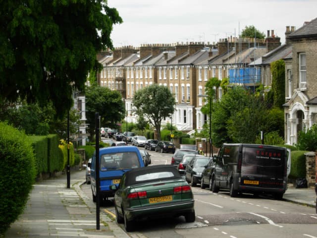 A leafy street of large Victorian houses with front gardens