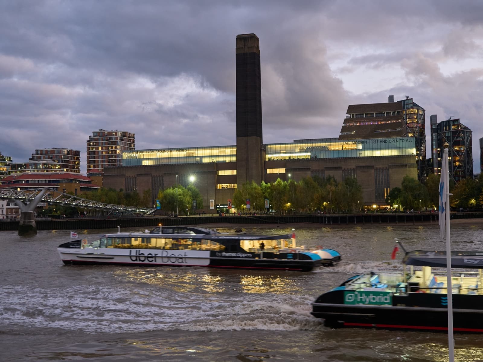 The brick former power station of Tate Modern with its central chimney beside the Thames