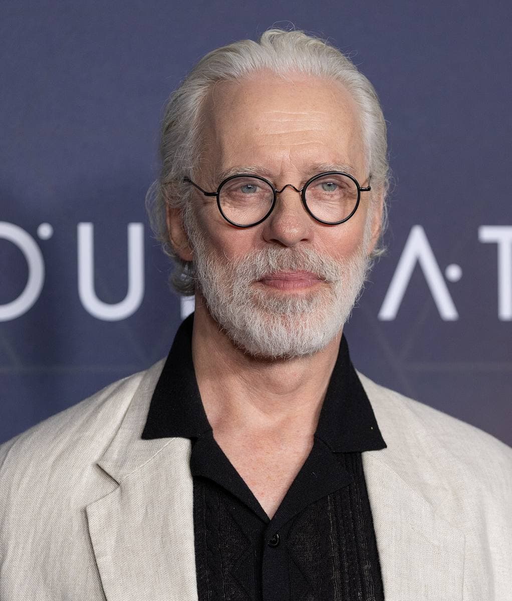 A grey-haired man in a dark jacket