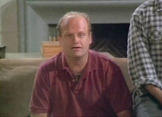 Kelsey Grammer in a red polo shirt on a living-room set, mid-sentence