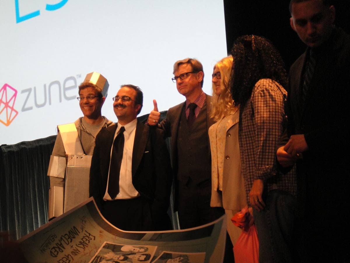 Paul Feig in a suit standing with fans in costume