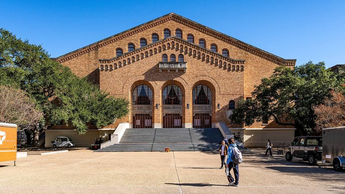 A long brick gymnasium with three tall arched windows over a broad flight of steps