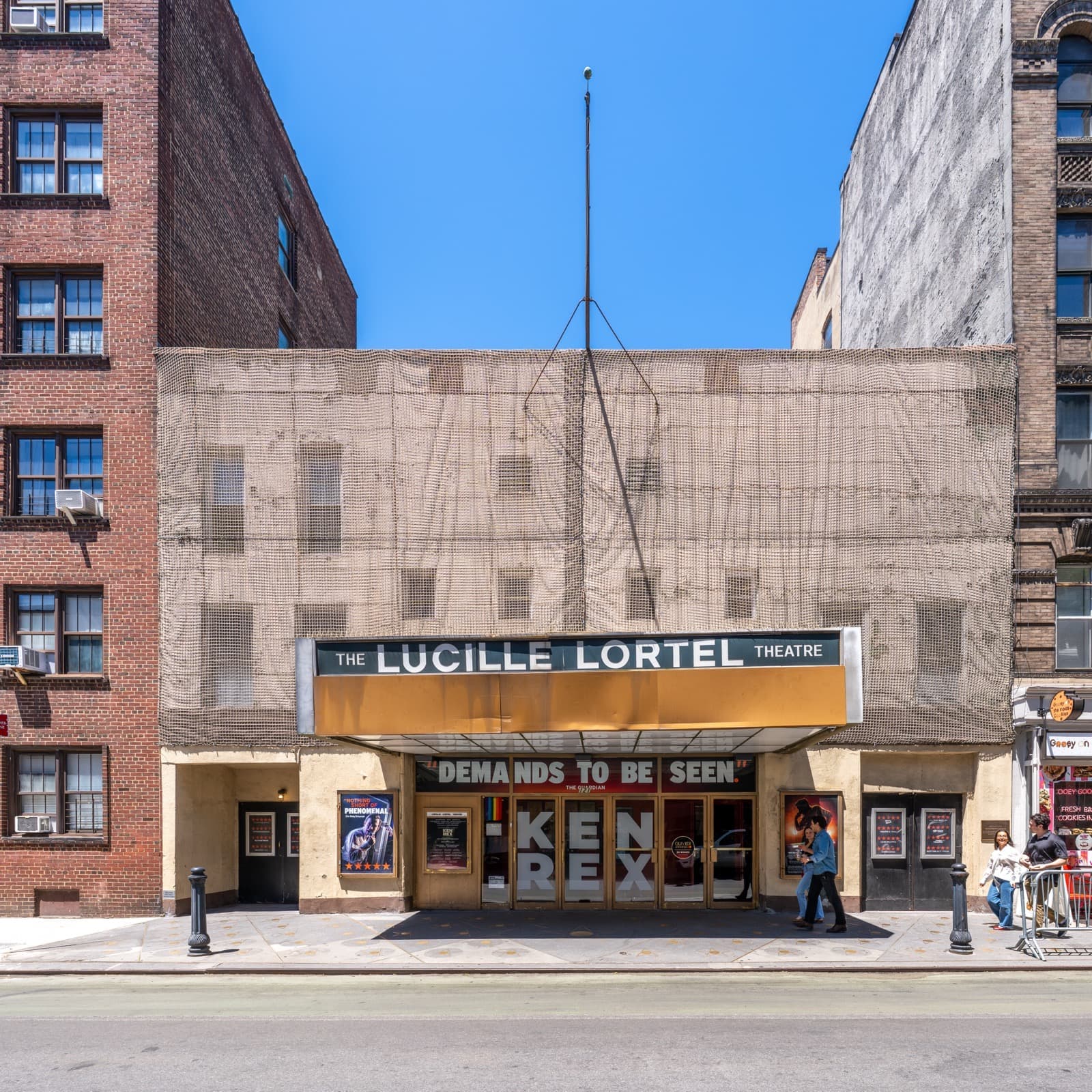 A narrow theatre front with a marquee on a West Village street