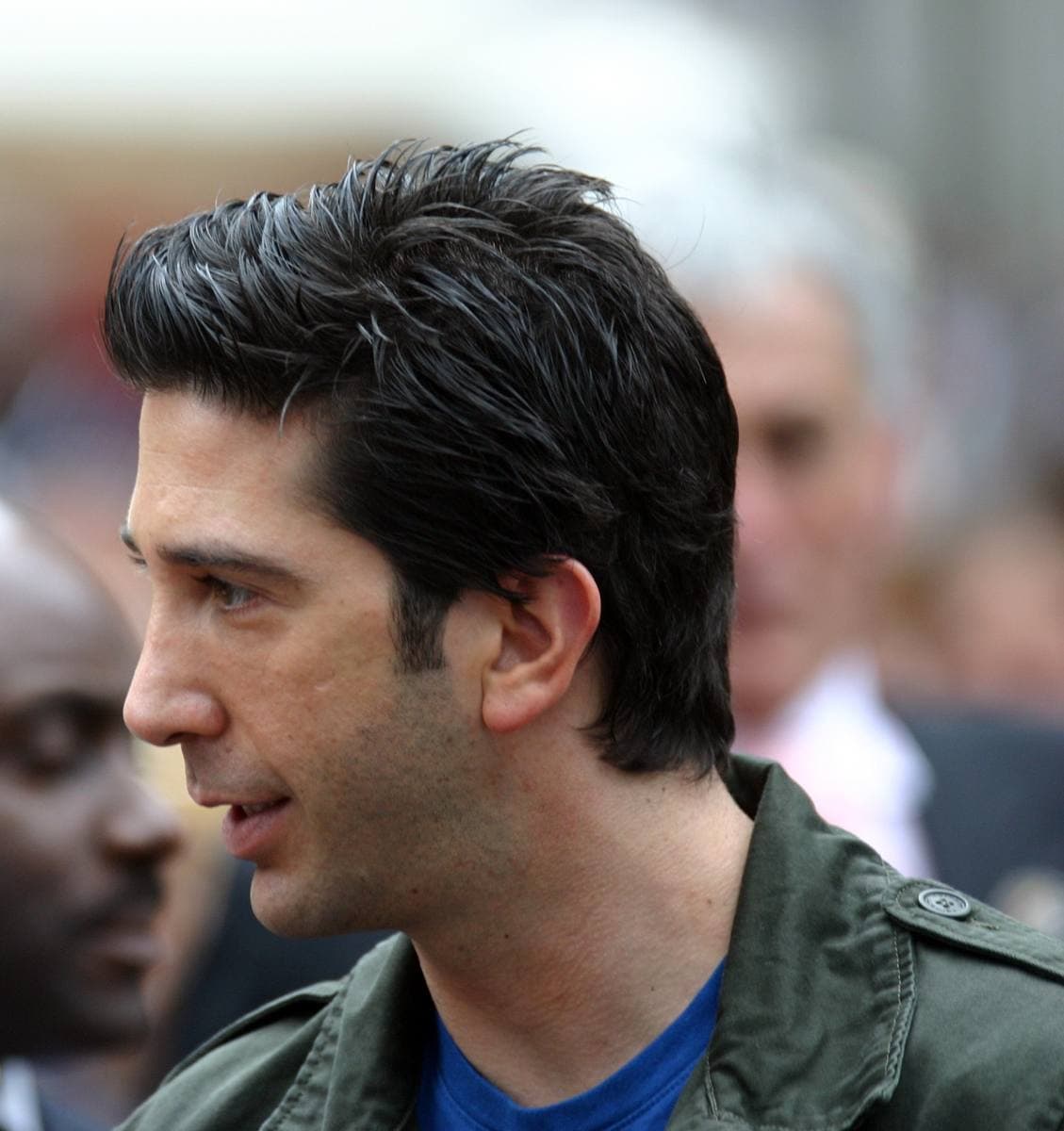 David Schwimmer in profile, dark hair, in a green jacket