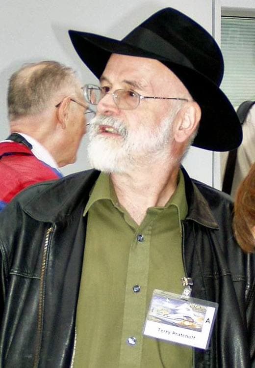 A bearded man in a black hat and glasses