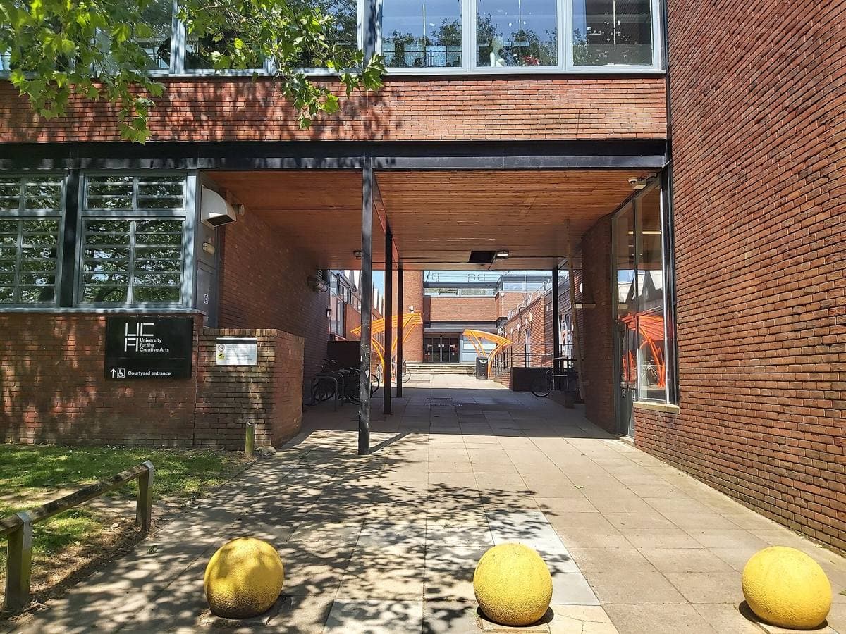 A modern campus entrance with a paved courtyard