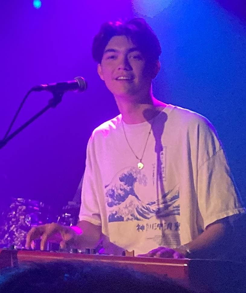 William Gao at a keyboard on a dimly lit stage