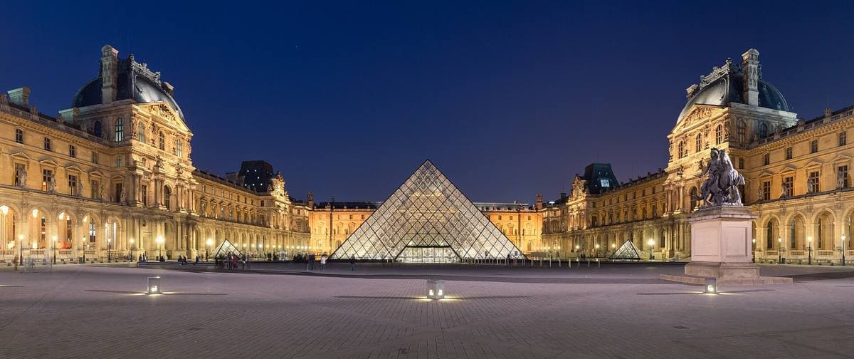 The Louvre courtyard at night with its glass pyramid lit up