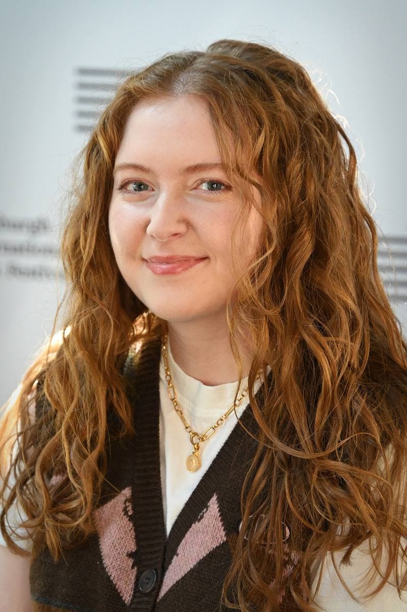 Alice Oseman, a person with short hair and glasses, at a book festival