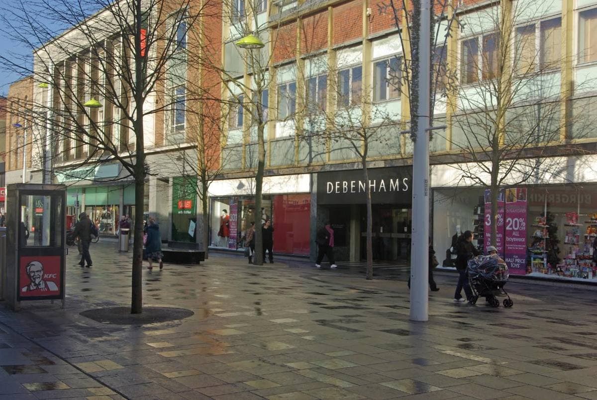 A pedestrian high street with shops either side