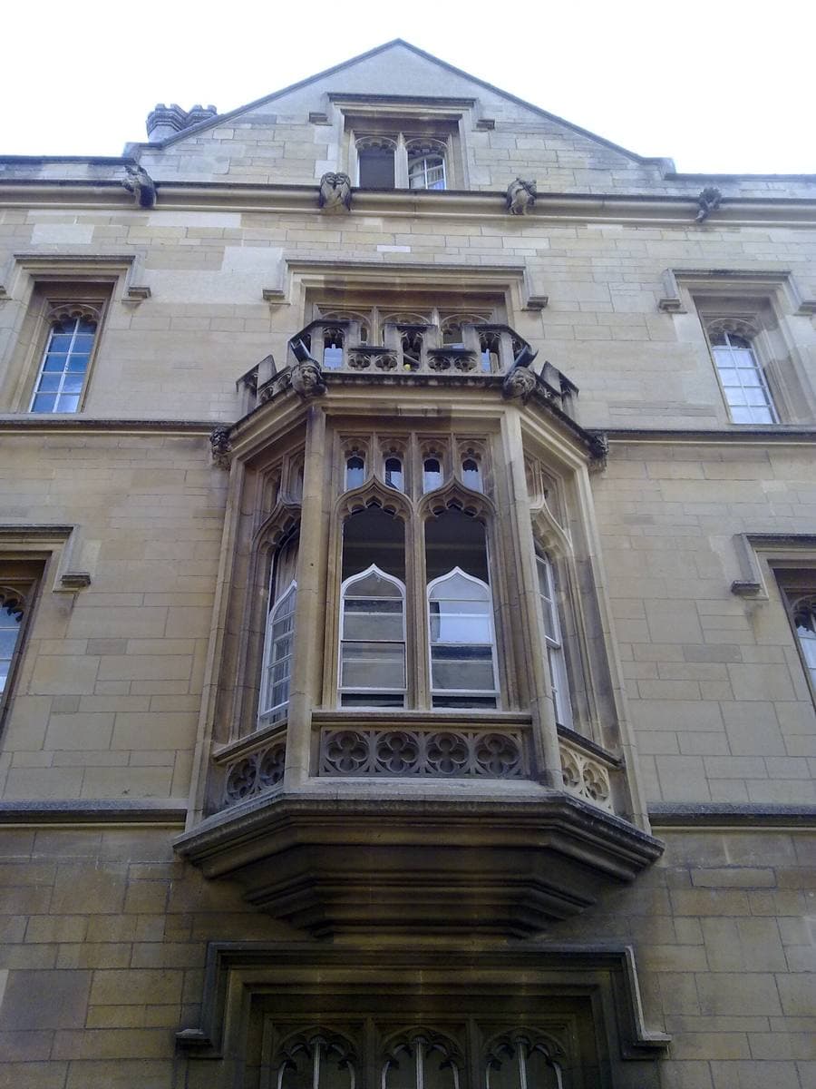 A stone bay window with leaded panes on an old college building