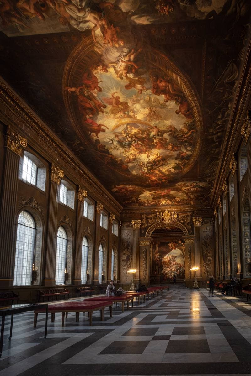 A long hall with a painted ceiling and walls in gold and blue