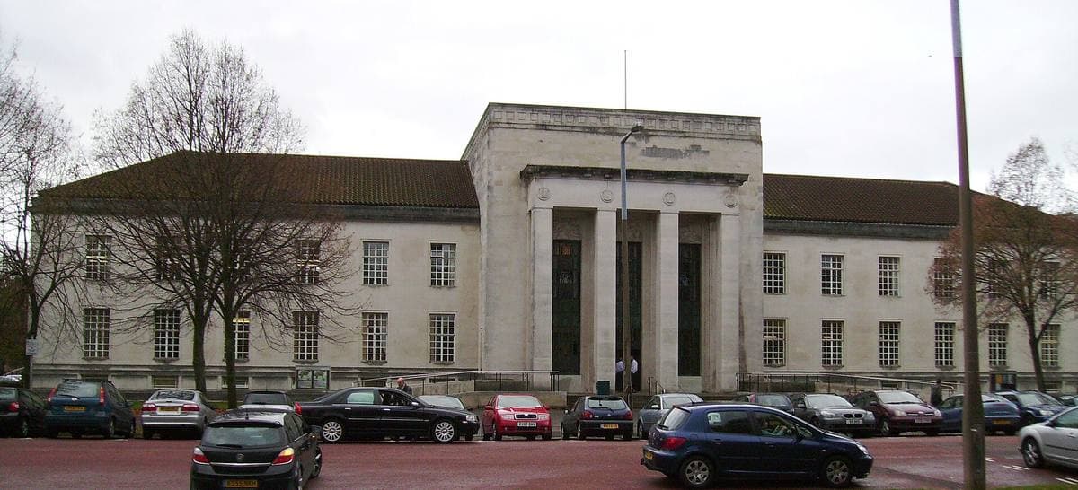 A long pale stone building with tall columns at its entrance