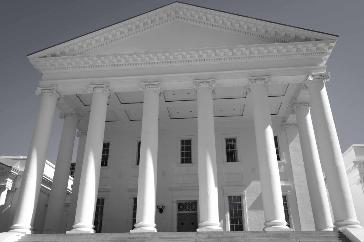 A white temple-fronted capitol on a hill