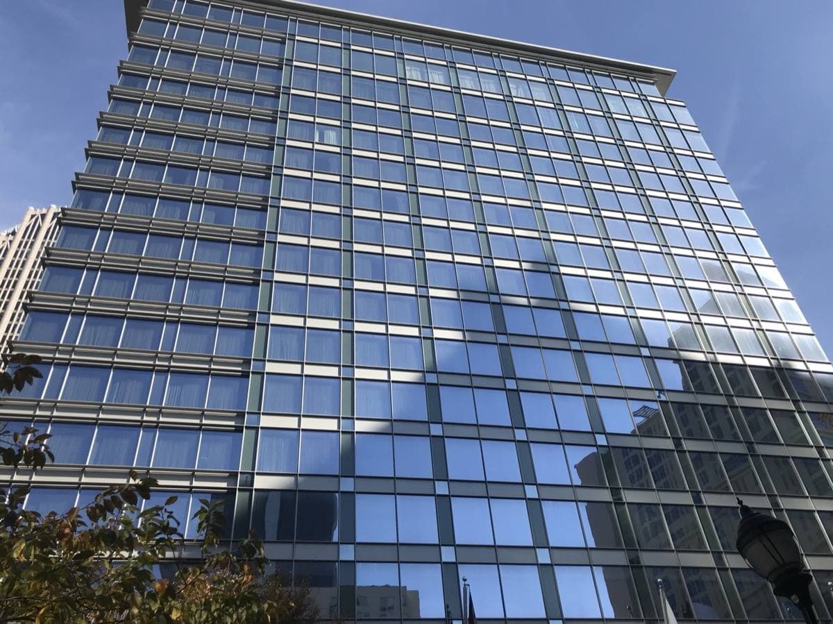 A glass and stone hotel tower in uptown Charlotte