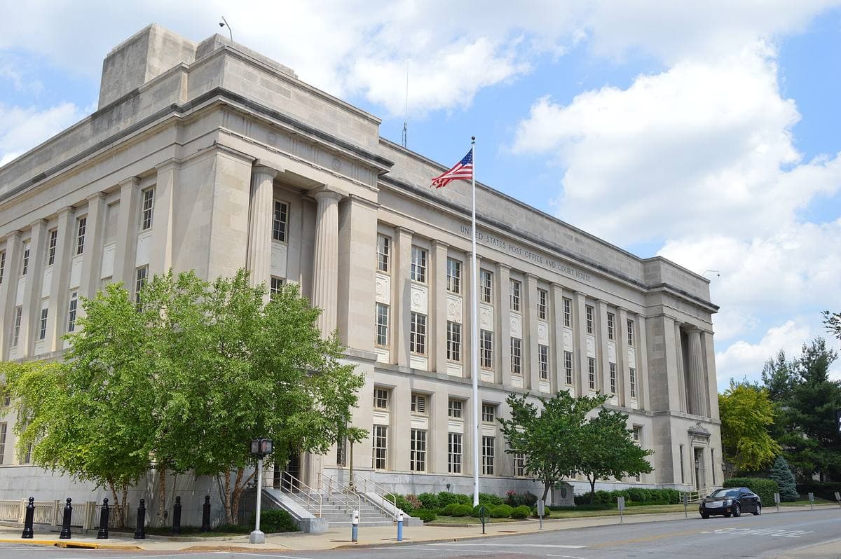 A pale stone 1930s federal building with tall windows