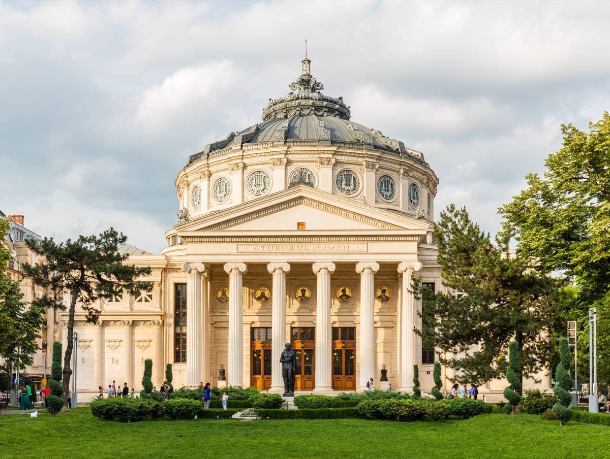 A domed circular concert hall with an Ionic portico in evening light
