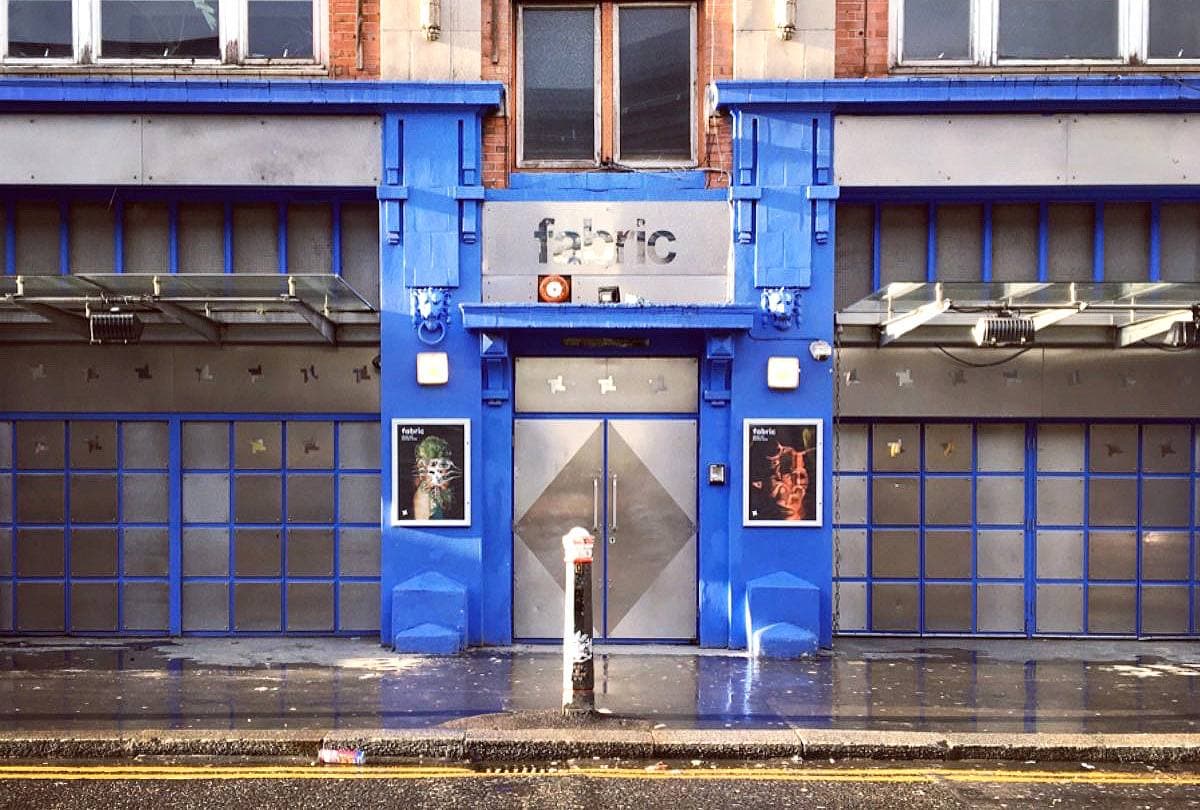 A brick warehouse frontage with a plain black door on a London street