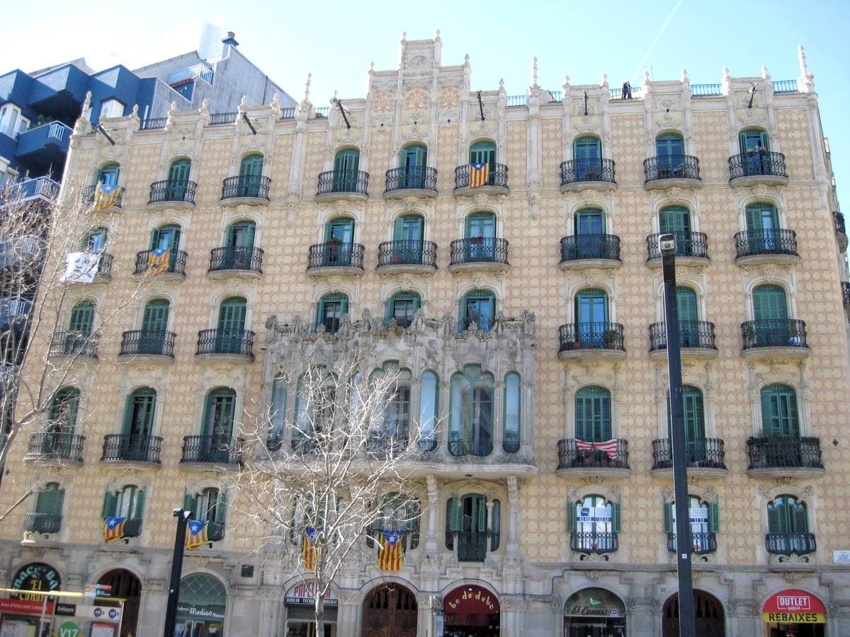 A modernista apartment block with stone bay windows and iron balconies