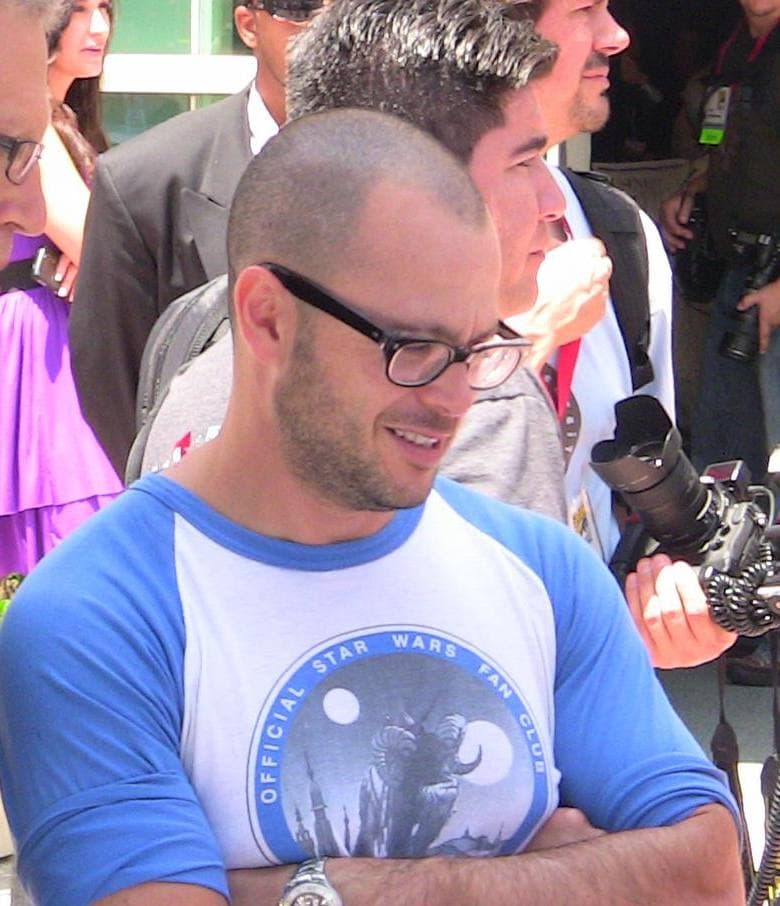 Damon Lindelof in glasses and a baseball T-shirt, arms folded