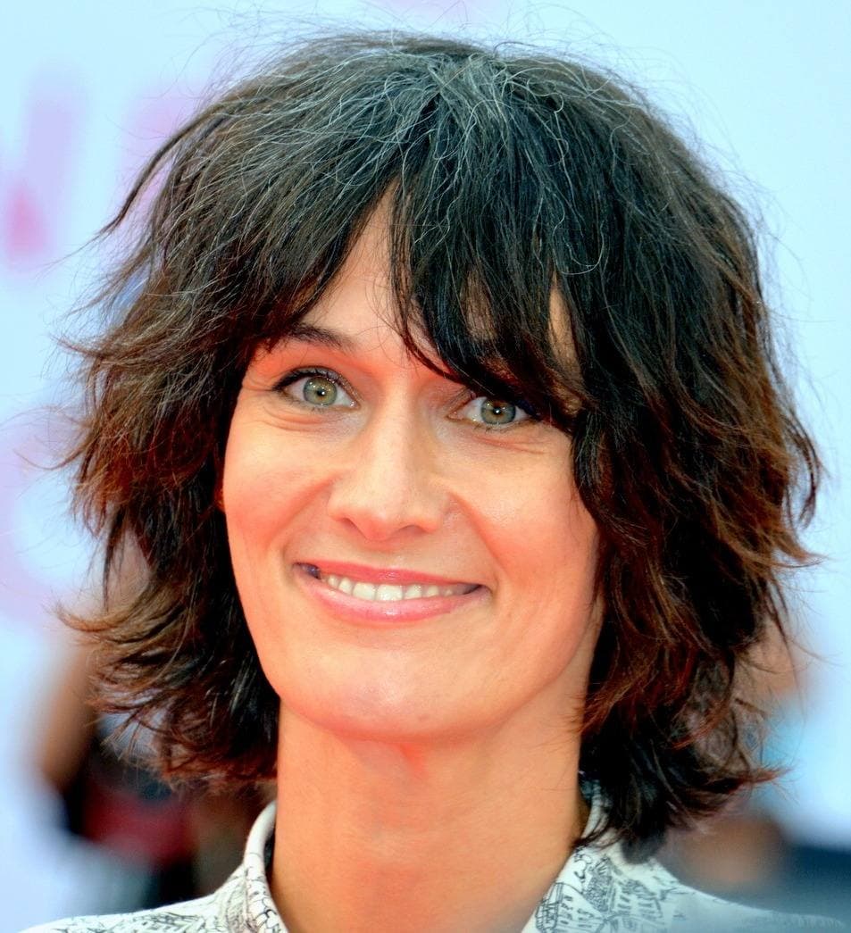 Clotilde Hesme smiling, dark hair falling across her forehead