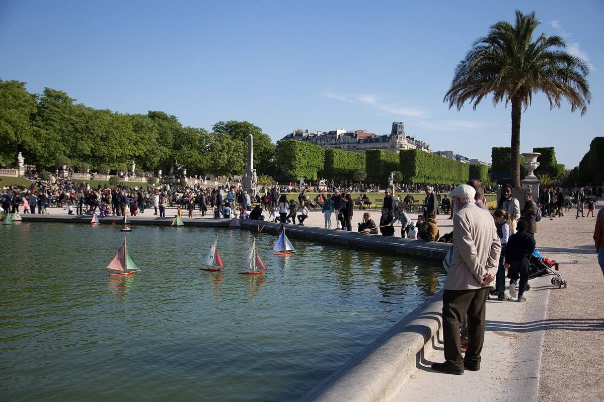 Model sailing boats on a large stone pond in a formal garden