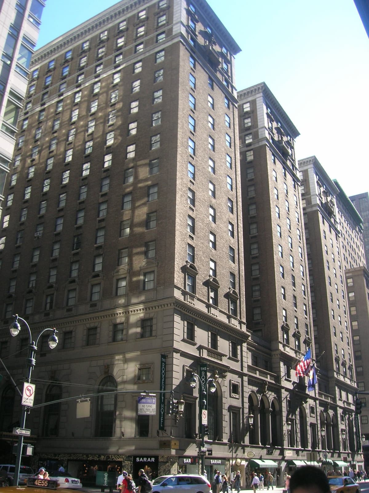 The tall brick Roosevelt Hotel with flags over its entrance