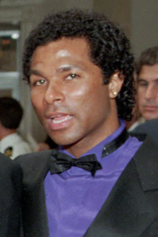 Philip Michael Thomas in a black dinner jacket and violet shirt