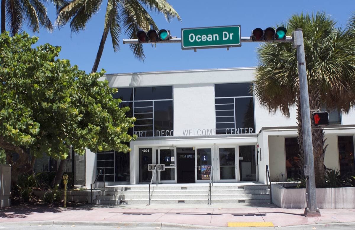 A low white Deco building under an Ocean Dr street sign