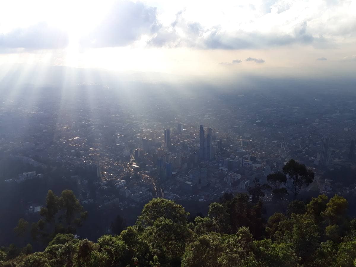 Bogotá's towers and old centre spread across a high plain below a green hillside
