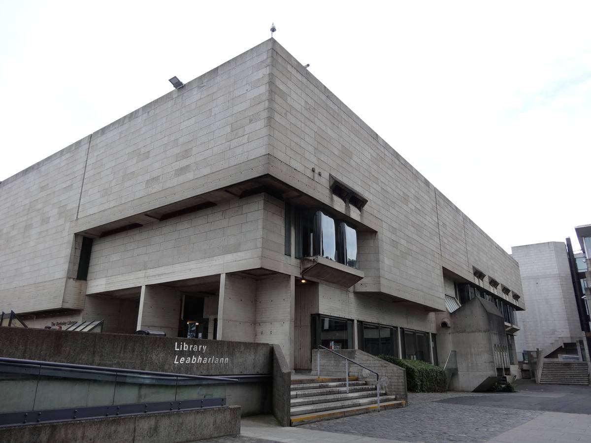 A brutalist concrete library with deep window bays above a stepped entrance