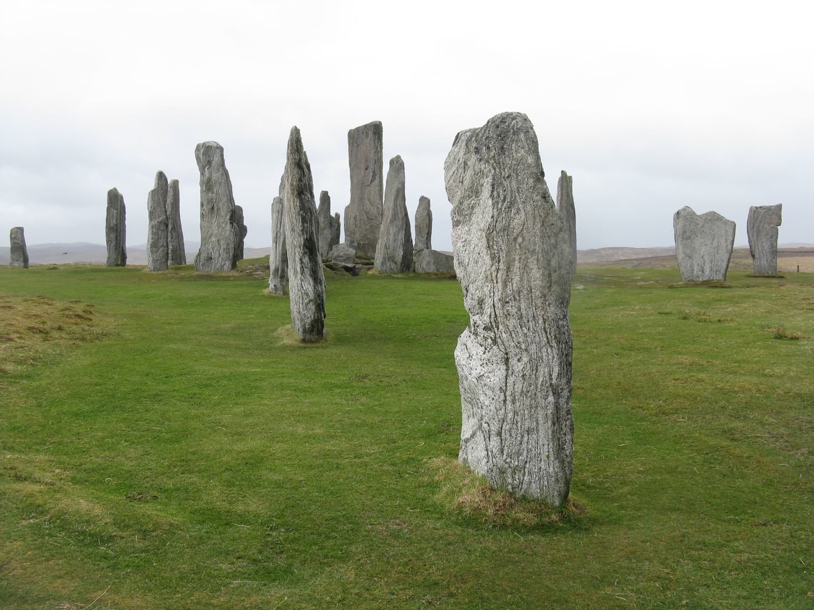 Tall grey standing stones on open grassland