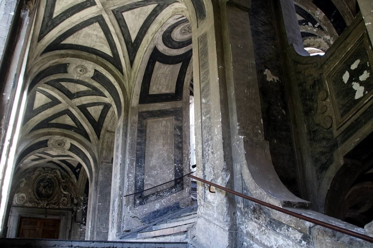 Arched vaults and balustrades of a monumental open staircase seen from below